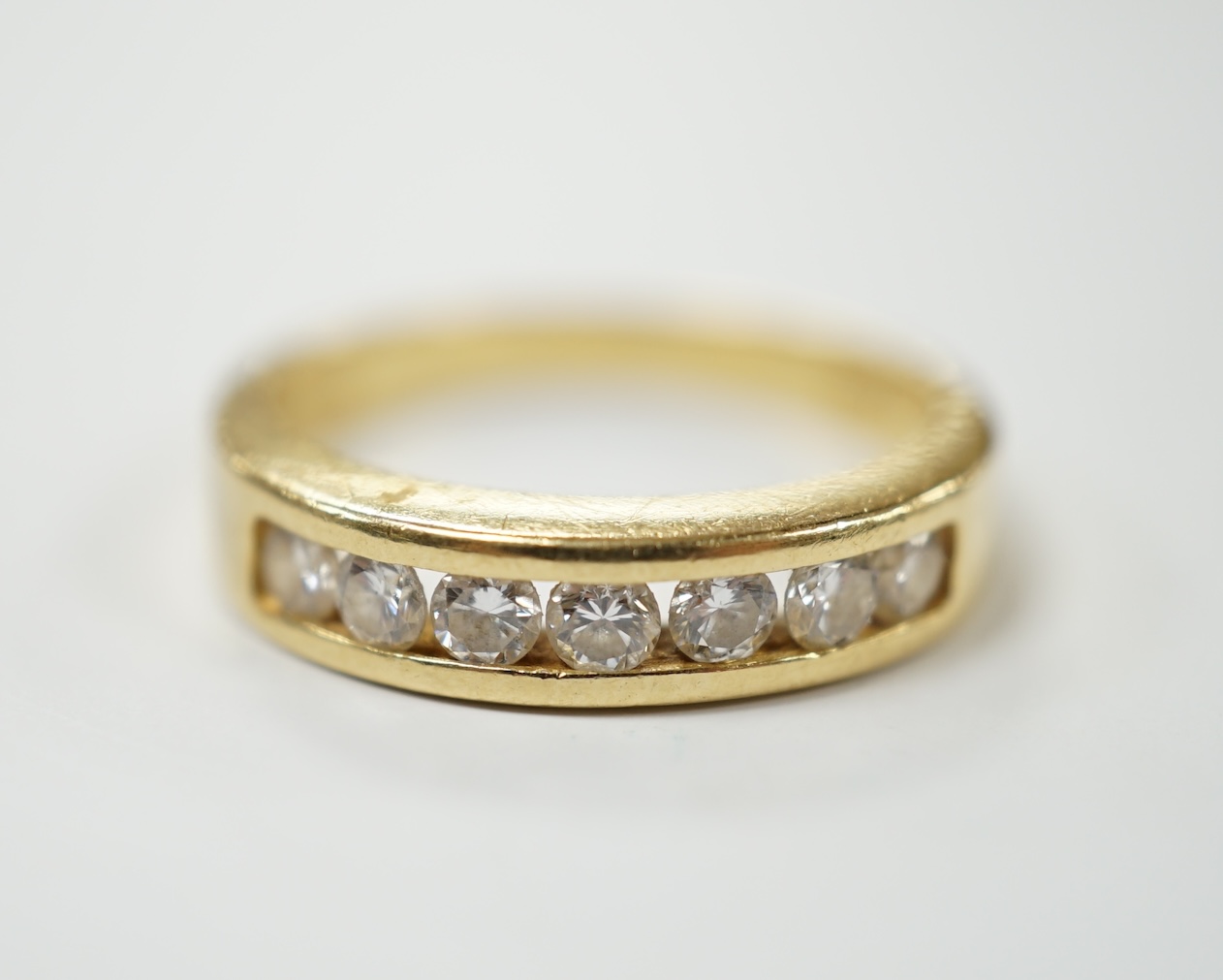 A modern 18ct gold and seven stone channel set diamond half hoop ring, size O, 5.2 grams. Condition - fair to good